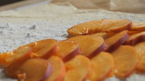 Galeta with nectarine. Raw dough on which the hands of a female cook put pieces of nectarine in the home kitchen