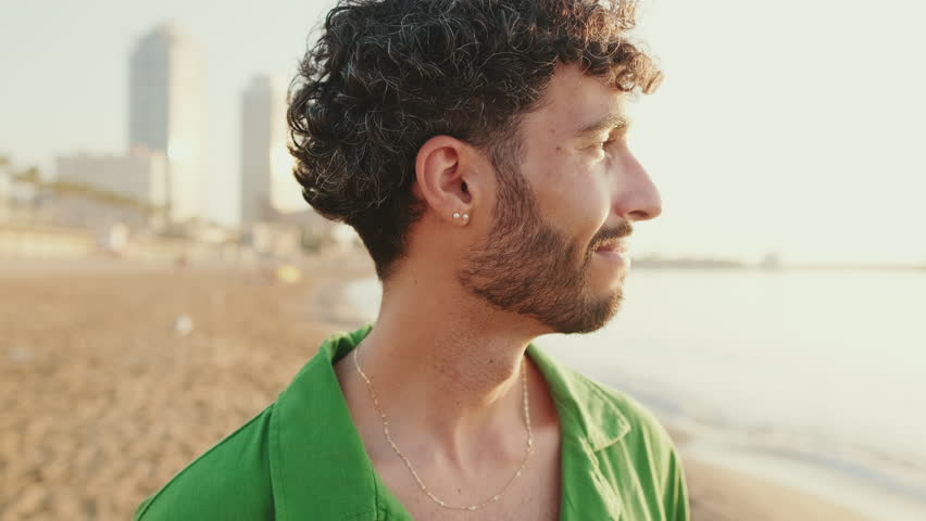 Close-up of young guy turning his head and looking at the camera with smile