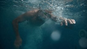 Underwater view of professional swimmer training in swimming pool, 4k 120 fps super slow motion raw video. Triathlete swim in black wetsuit  - Powered by Shutterstock - Get 15% off with code: PIKWIZARD15