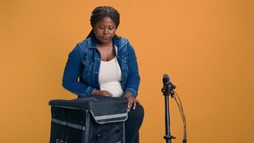 African american courier carefully carrying basket of fruits from food delivery bag. Smiling black woman delivering fresh fruits and vegetables with bicycle as transportation. - Powered by Shutterstock - Get 15% off with code: PIKWIZARD15