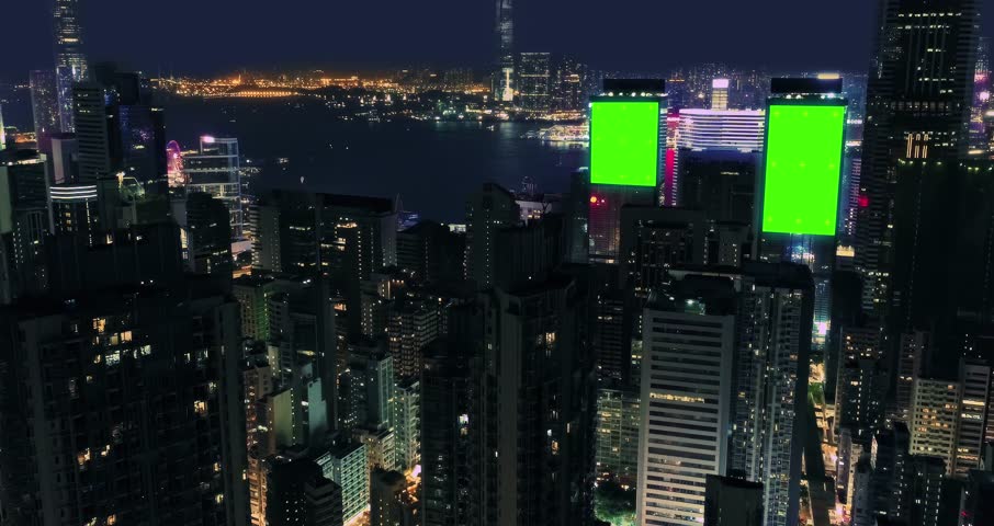 AERIAL. Top view of skyscrapers and green screen build board with tracking point. Bird view of modern city at night streets. Royalty-Free Stock Footage #1108623081