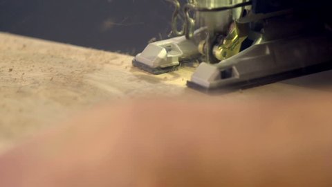 Close up footage of a saw sawing the wooden plank by a wood worker in the shop, close up footage.