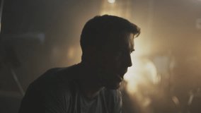 Close-up shot of strong man lifting up kettlebell and breathing heavily while a group of people exercising together at gym - Powered by Shutterstock - Get 15% off with code: PIKWIZARD15