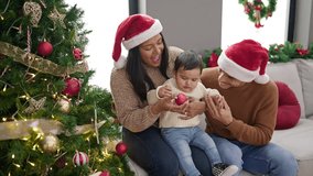 Couple and son decorating christmas tree at home - Powered by Shutterstock - Get 15% off with code: PIKWIZARD15
