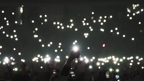 Many fun people lift hand up hold cell phone flash light. Fan crowd wave flashlights. Epic live music concert atmosphere. Big open air k pop arena. Cool night fest. Lot joy men hang out. Kpop chill.: stockvideo