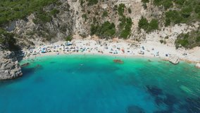 Aerial view video of sun beds and umbrellas in famous Agiofili beach