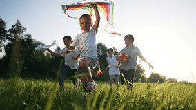 happy family.Little children run with kite along green grass in park in nature.Summer game for child on vacation with kite.Kid run in nature with kite in summer.Freedom and dream of children in park - Powered by Shutterstock - Get 15% off with code: PIKWIZARD15
