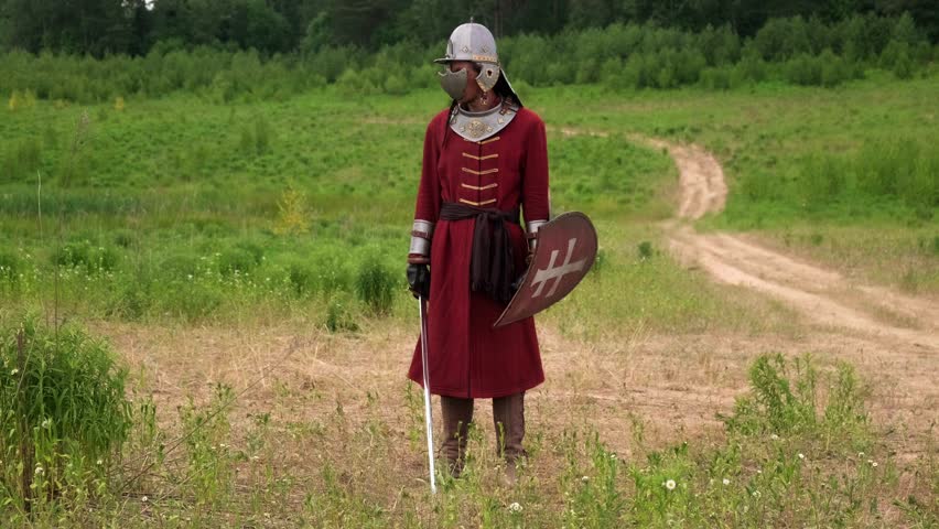 a guy dressed in a knight costume waves a sword, a man dressed in an ancient warrior costume waves a sword