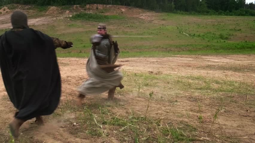 two warriors fight with swords, two knights fight with swords, two men dressed in costumes of ancient warriors fight with swords