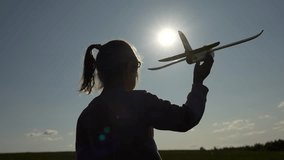 Child running with toy plane in hand in summer field. Child dreams of flying. Happy kid running in field, playing with toy airplane