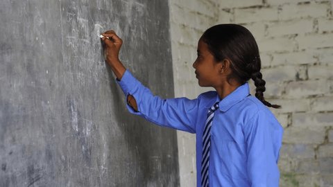 Happy Indian school girl child standing  in front of black chalkboard background. Education Concept or Back to School 库存视频
