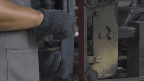 A blacksmith polishes the knife on the sandpaper, slow motion shot