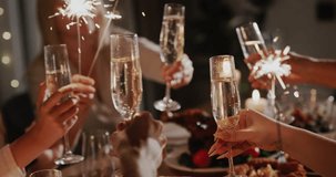 A friendly family clinks glasses of sparkling wine at the festive table.