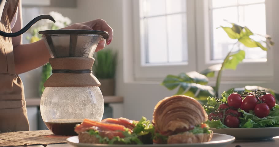 Woman hands prepare morning drip filter coffee. Breakfast at home with coffee and croissant sandwiches Royalty-Free Stock Footage #1108656643