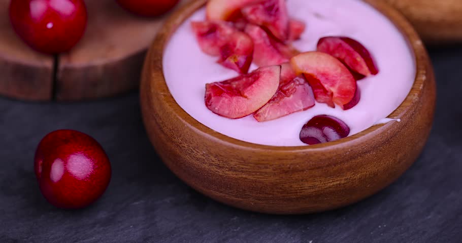 Fresh yogurt with cherry flavor and whole juicy cherry berries, homemade sweet yogurt with pieces of cherry berries | Shutterstock HD Video #1108660243