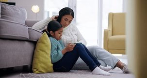 Phone, child and mother help with a children and education online game on living room floor. Mom, young girl and mobile app with gaming and watching video at home with bonding, support and care