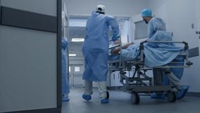 African American doctor with female colleague opens doors to operation room for other medics. Surgeons transport elderly patient to surgery. Old man sleeps before operation. Medical staff at work. - Powered by Shutterstock - Get 15% off with code: PIKWIZARD15