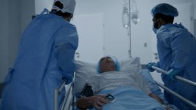 Surgeons transport senior patient down the clinic corridor to operation room. Medics open doors for other doctors with patient. Old man lies on gurney under drip and with pulse oximeter on his finger. - Powered by Shutterstock - Get 15% off with code: PIKWIZARD15