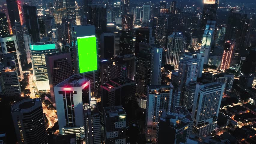 AERIAL. Top view of skyscrapers and green screen build board with tracking point. Bird view of modern city at night streets. Royalty-Free Stock Footage #1108672225