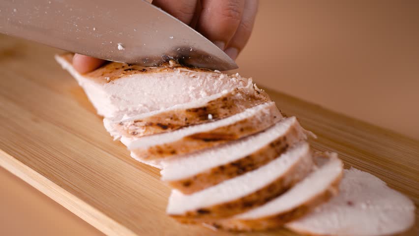 Fried chicken breast cut into slices on a wooden board. Royalty-Free Stock Footage #1108673537