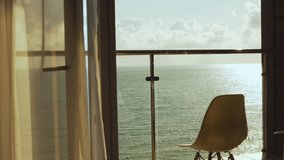Beautiful View of the Sea Beach Sky Clouds Sun at Sunset from the Balcony Window of a Luxury Hotel Apartment. Sea in Sunlight. Terrace Chair and Amazing Ocean View. Sea View from the Window, Relax. - Powered by Shutterstock - Get 15% off with code: PIKWIZARD15