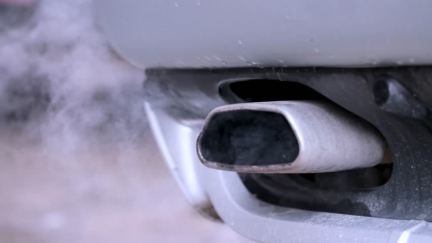 Smoke from the exhaust pipe of a car.