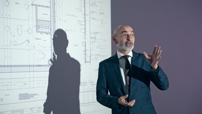 A middle-aged Caucasian business person explaining a design using a projector screen. Royalty-Free Stock Footage #1108679501