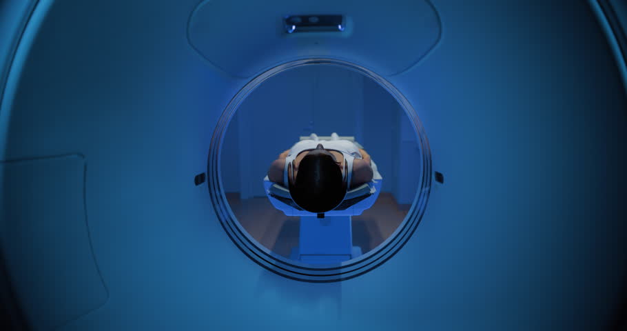 In the Medical Laboratory, Footage of an Anonymous Female Patient Lying on a CT or MRI Scan Bed Undergoes Scanning Procedure. Bed Moves Towards Camera as Examination Begins. Dynamic Tracking Shot
