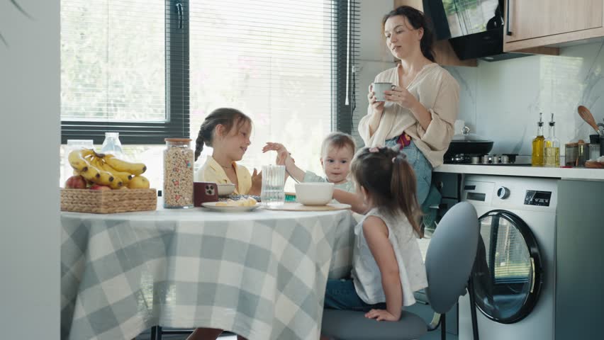 Mother and Three Baby Daughters have Breakfast in a Cozy Kitchen Interior Royalty-Free Stock Footage #1108691295