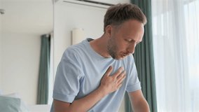 Sudden Heart attack young lonely man under stress from overwork at home apartment. Person suffering from chest pain and hard breathing - Powered by Shutterstock - Get 15% off with code: PIKWIZARD15