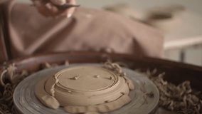 work on a potter's wheel. close-up of a man's hand. slow-motion video. clay processing. High quality video in FullHD format.