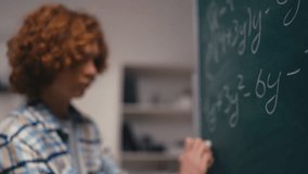 Confident teenage boy solving algebra equation on chalkboard, good at math - Powered by Shutterstock - Get 15% off with code: PIKWIZARD15