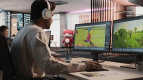Indian Male Game Designer Using Desktop Computer With 3D modelling Software To Design Unique Characters And World For Immersive RPG Video Game. Man Working In Game Development Company Diverse Office.