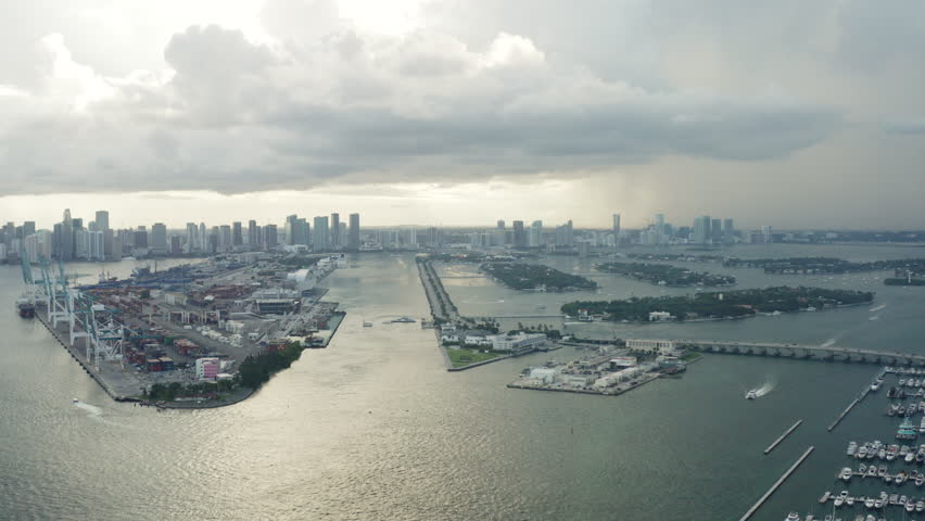 Aerial of Miami and south beach the ocean and the cruise pier, a motorized parachute or paraplane flying in the sky. Florida 
