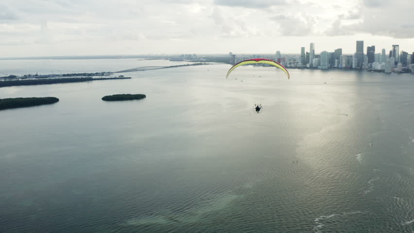 Aerial of Miami and south beach the ocean and the cruise pier, a motorized parachute or paraplane flying in the sky. Florida 