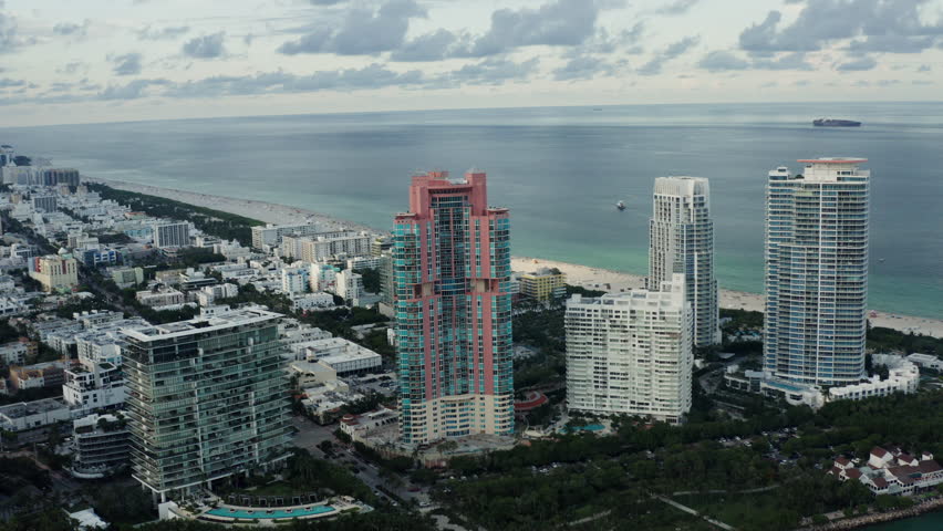 Aerial of Miami and south beach the ocean and the cruise pier, a motorized parachute or paraplane flying in the sky. Florida 