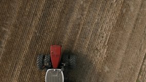 Big red Tractor Pulling Disc Harrow Through Field in Preparation soil for Planting new crops, Agriculture. Aerial view of tractor plowing the field. slow motion video.