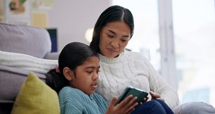 Phone, kid and mother support with a children and education online game on living room floor. Mom, young girl and mobile app with gaming and watching video at home with bonding, lounge and care