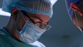 Face of mature male surgeon wearing cap, mask and eyeglasses. Close up portrait of a doctor during his work. - Powered by Shutterstock - Get 15% off with code: PIKWIZARD15