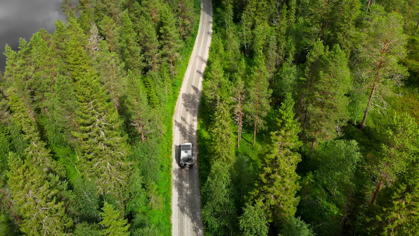 Nomad self converted off grid camper van drive on secluded forest road. 4x4 Camper with solar panels, extra tire rack and bikes on back ride on off road gravel road in Norway | Shutterstock HD Video #1108731803