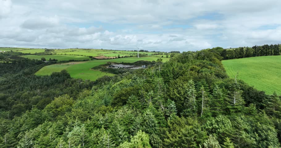 Windmill with blades on the background of forests and green fields 4k