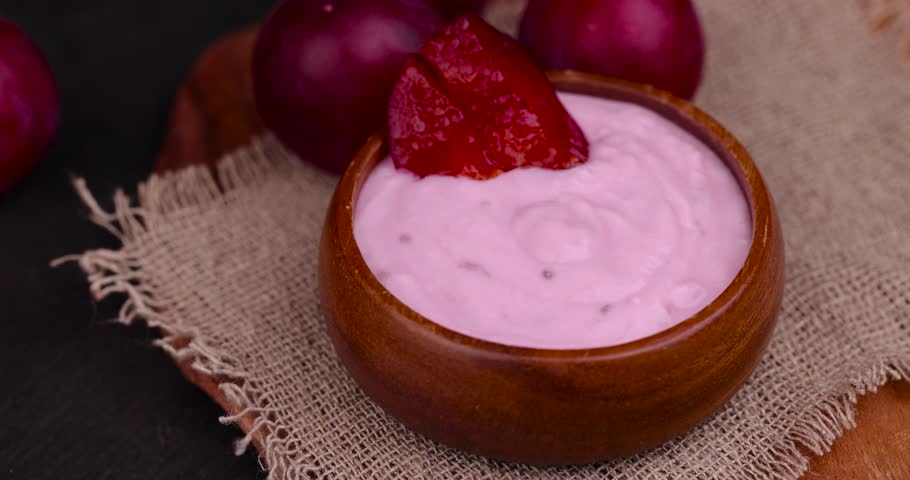 Add plum slices to flavored pink yogurt , cooking dairy products with flavor and pieces of red plum | Shutterstock HD Video #1108735085