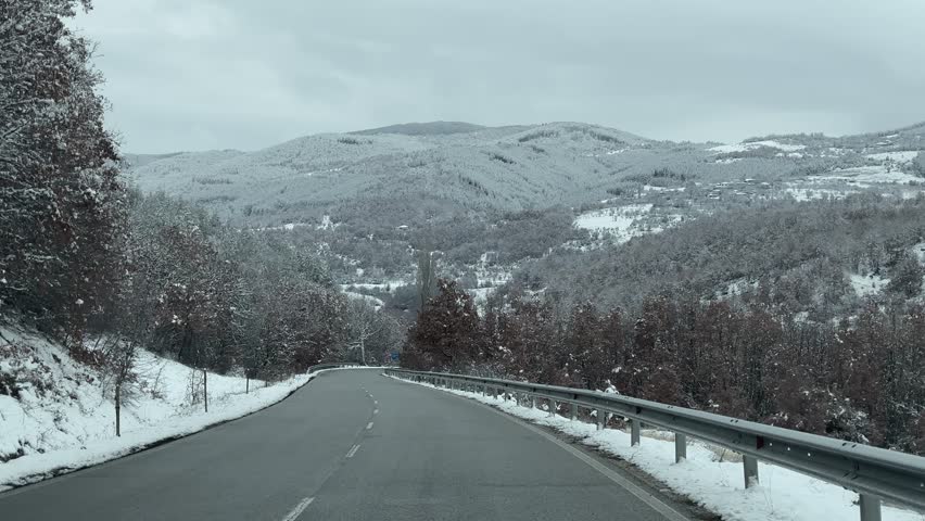 Winter drive on beautiful snowy forest mountain road