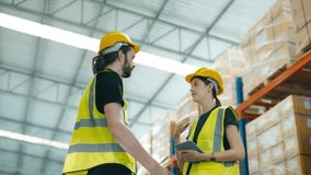 Smiling workers in distribution warehouse having a cheerful conversation. They wearing vest and safety helmet in work - Powered by Shutterstock - Get 15% off with code: PIKWIZARD15