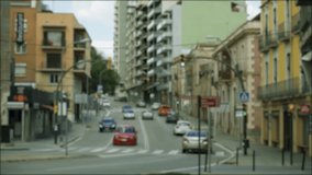 Busy traffic of cars on the street of a small Spanish town. Blurred background video.