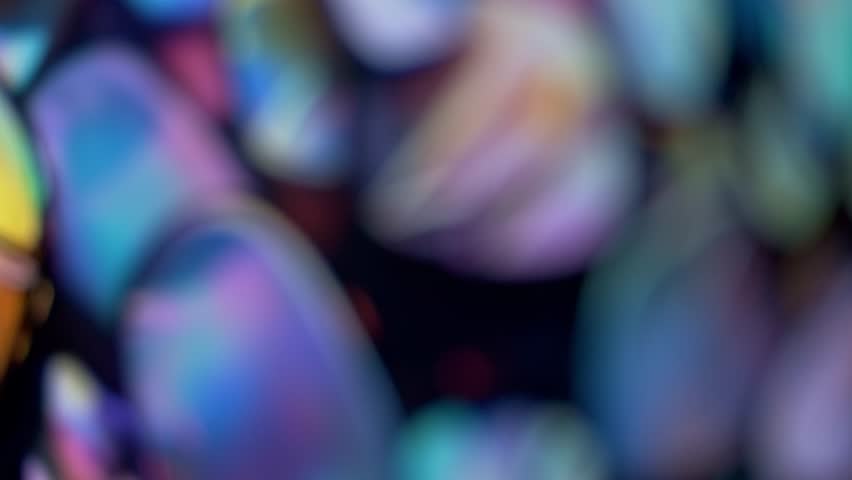 Defocused abstract background. A captivating tapestry of opulent opal fragments unfolds, each one showcasing a myriad of iridescent hues. Like tiny puzzle pieces, these gemstones seamlessly connect Royalty-Free Stock Footage #1108749323