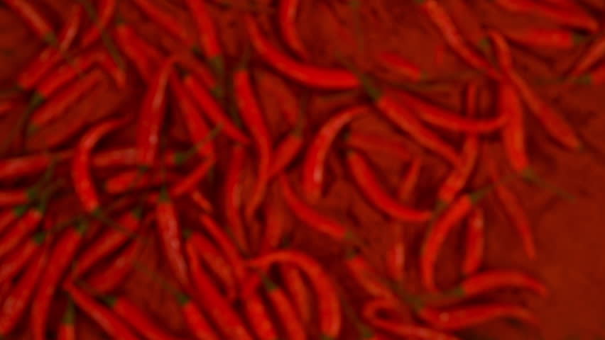 Super Slow Motion Shot of Flying Fresh Chilli Peppers Isolated on Black Background at 1000 fps.