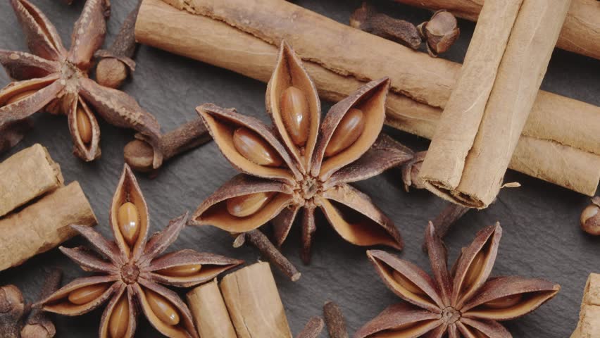 Lots of three spices for mulled wine – star anise, cinnamon and clove slowly scroll clockwise, macro video footage. A great background for your projects. Royalty-Free Stock Footage #1108754223