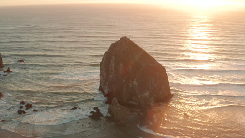 Circling aerial shot of Haystack rock sea stack at sunset Royalty-Free Stock Footage #1108757939