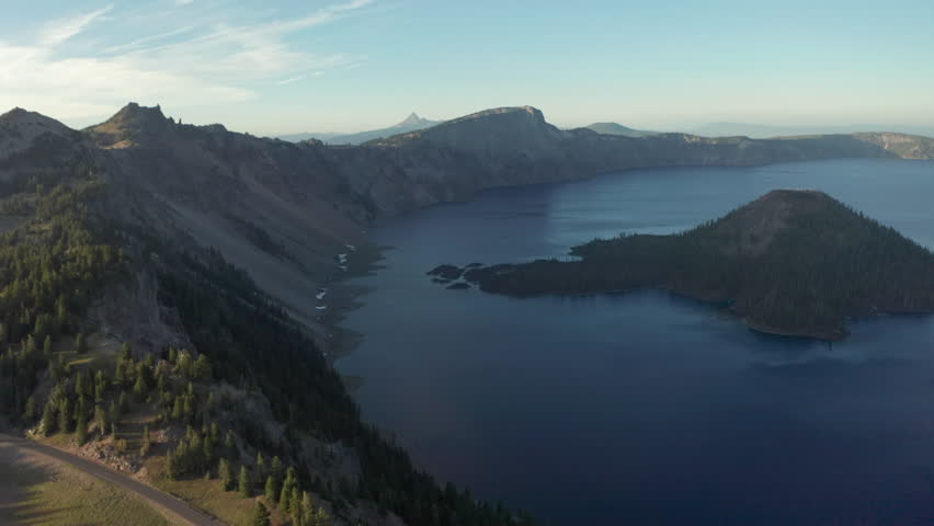 Aerial slider shot of Wizard Island and Crater Lake rim Oregon